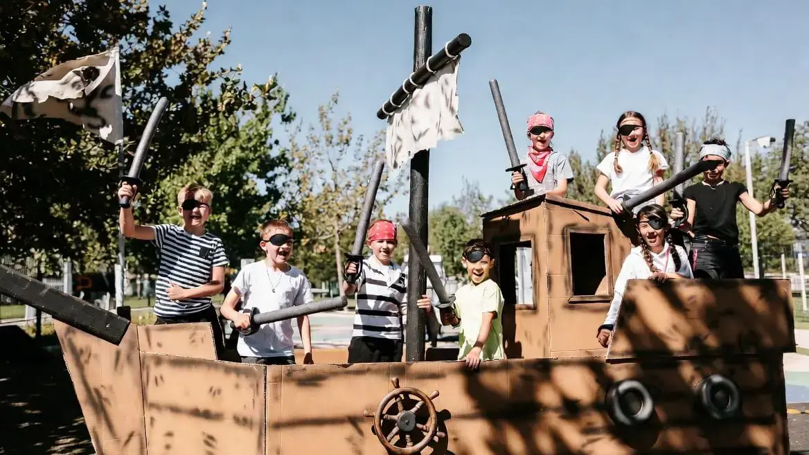 Enfants déguisés en pirates sur un bateau en carton lors d'une animation périscolaire